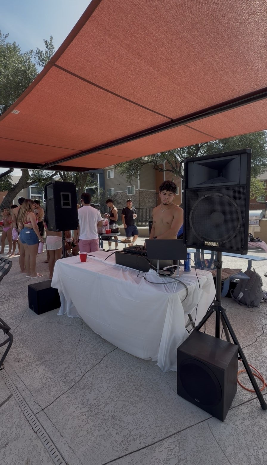 DJ Vinceanator performing outdoors under a canopy at a pool party with Yamaha speakers